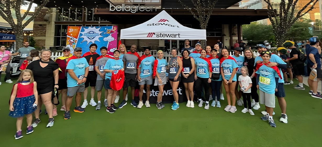 A group of Stewart employees at a super hero themed charity event