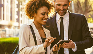 Image Real estate brokers review listing on a smart phone outside.